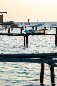 A man is fishing on an early morning from a jetty at the turkish west coast